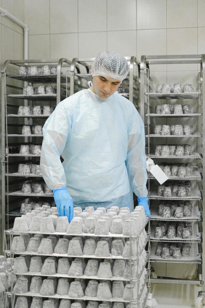 Kontrola kvaliteta u industrijskoj proizvodnji – radnik u zaštitnoj opremi proverava specijalizovane proizvode