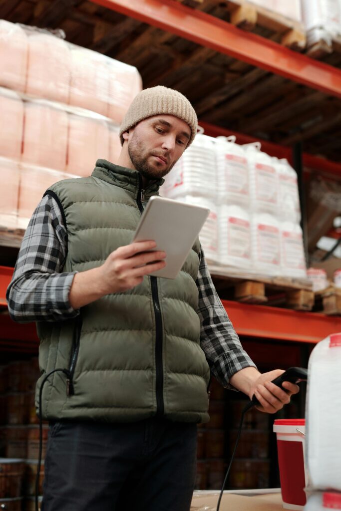 Radnik kontroliše robu i logistiku u magacinu pomoću tablet uređaja
